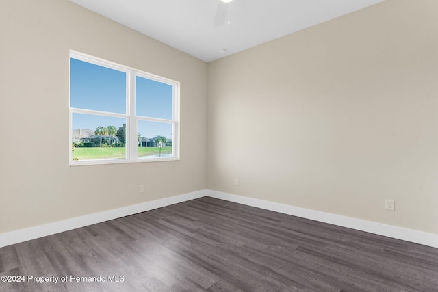 unfurnished room with ceiling fan and dark wood-type flooring