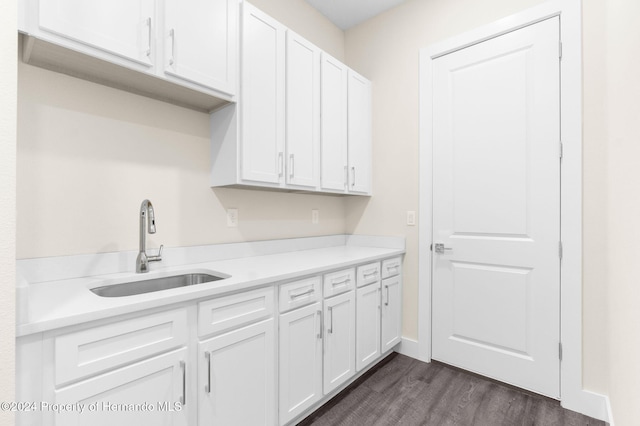 kitchen featuring dark hardwood / wood-style flooring, sink, and white cabinets