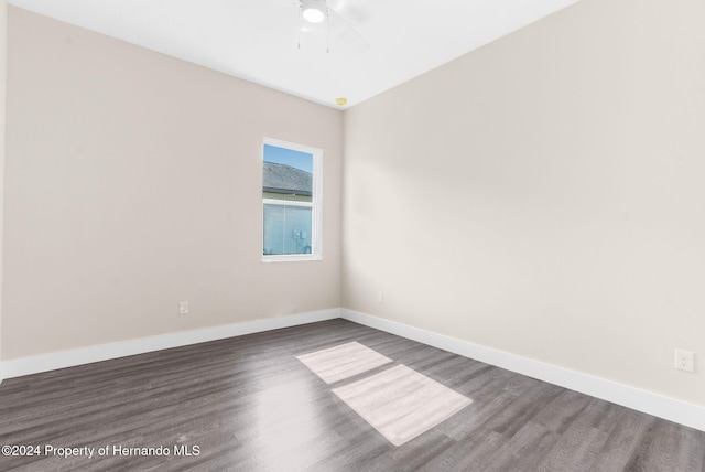 empty room with ceiling fan and dark hardwood / wood-style flooring