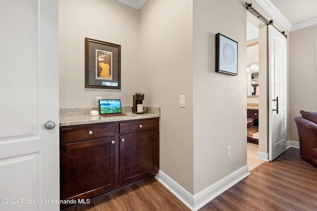 hallway featuring dark hardwood / wood-style floors, a barn door, and crown molding