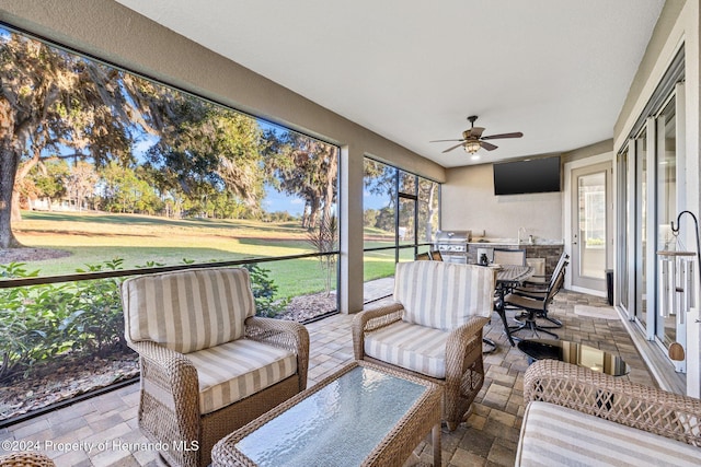 sunroom with ceiling fan, a healthy amount of sunlight, and sink