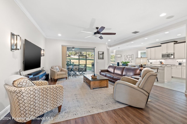 living room with ceiling fan, light hardwood / wood-style flooring, and ornamental molding