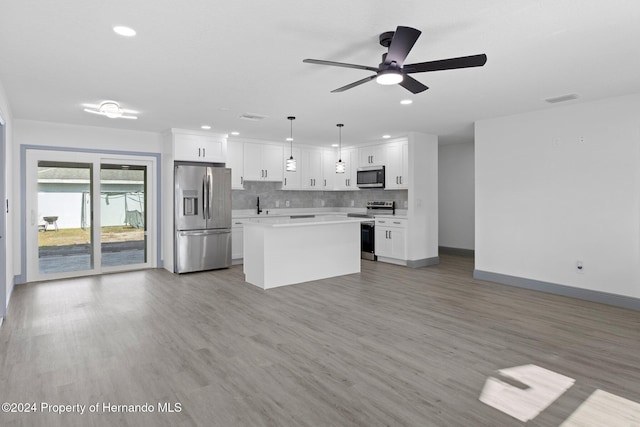 kitchen with white cabinets, light hardwood / wood-style flooring, decorative light fixtures, a kitchen island, and stainless steel appliances