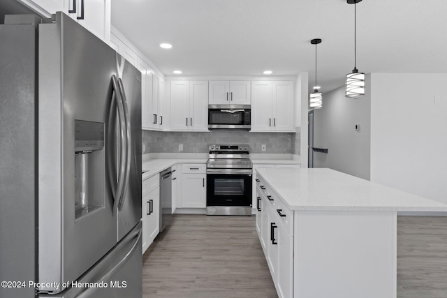 kitchen featuring a center island, hanging light fixtures, light hardwood / wood-style flooring, white cabinetry, and stainless steel appliances