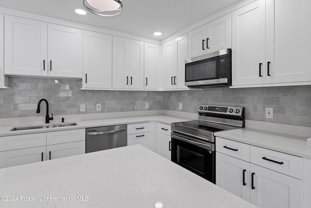 kitchen featuring backsplash, sink, white cabinetry, and stainless steel appliances