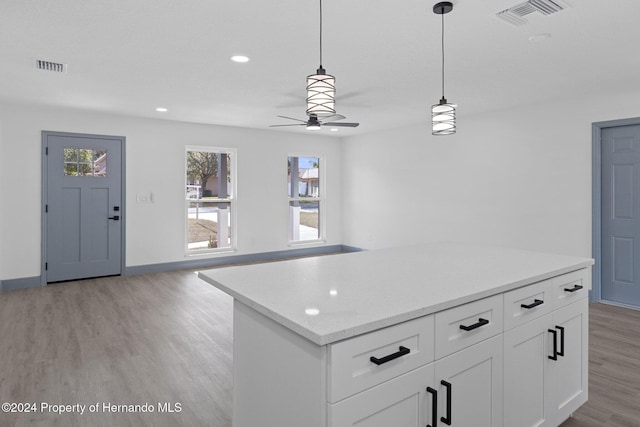 kitchen featuring decorative light fixtures, white cabinetry, ceiling fan, and light hardwood / wood-style flooring