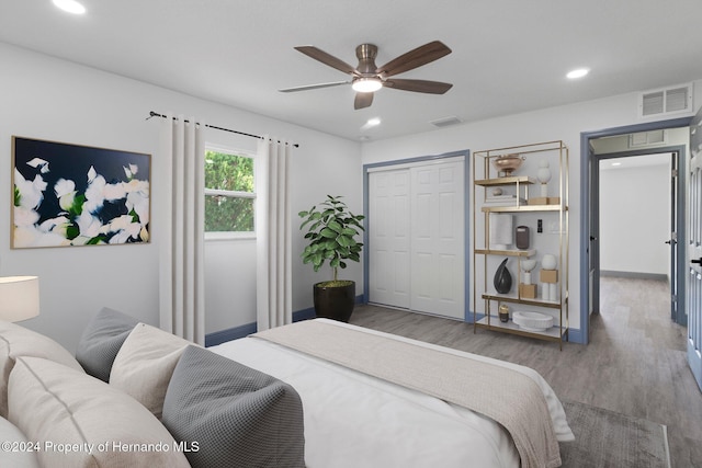 bedroom with hardwood / wood-style flooring, ceiling fan, and a closet