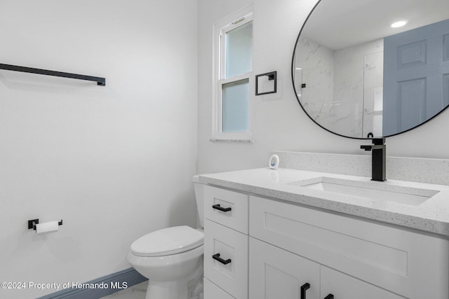 bathroom featuring vanity, toilet, and walk in shower