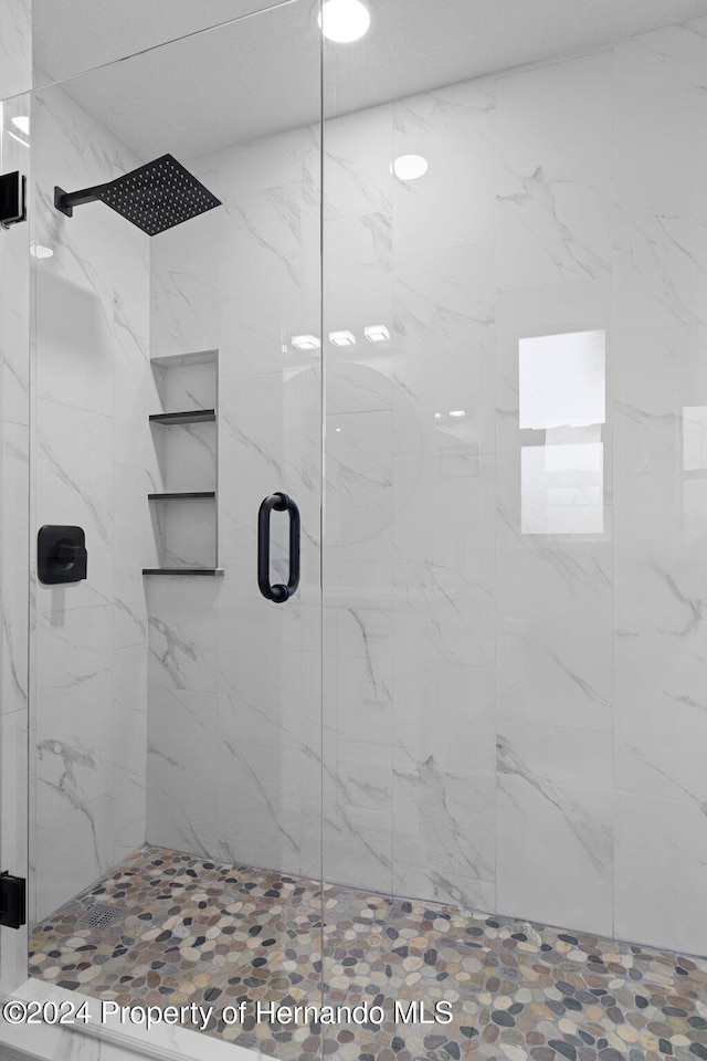 bathroom featuring a shower with shower door