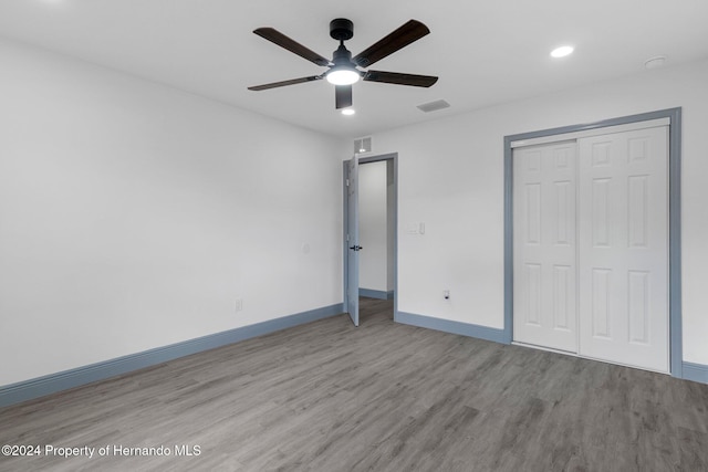 unfurnished bedroom with ceiling fan, a closet, and light wood-type flooring