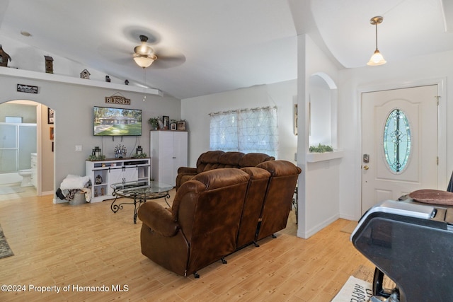 living room featuring light hardwood / wood-style floors, vaulted ceiling, ceiling fan, and plenty of natural light