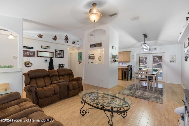 living room featuring ceiling fan, light hardwood / wood-style floors, vaulted ceiling, and french doors