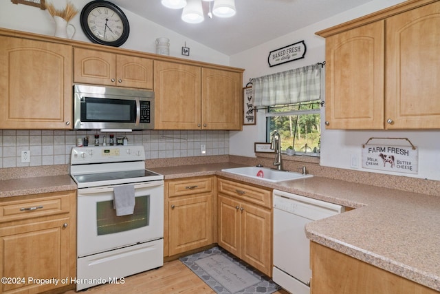 kitchen with white appliances, backsplash, light hardwood / wood-style floors, and sink