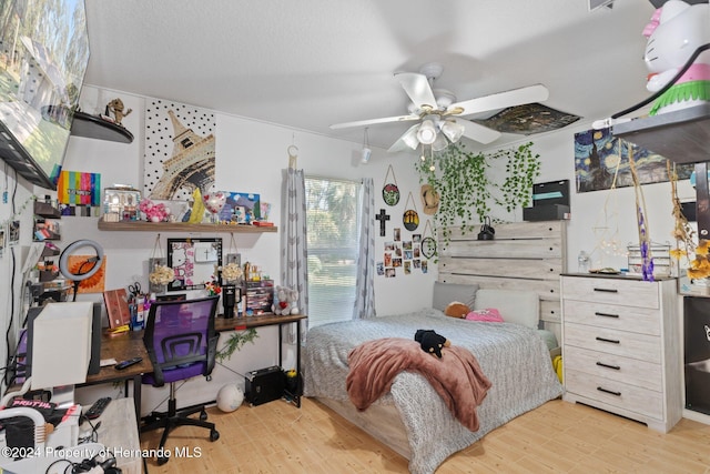 bedroom featuring a textured ceiling, light hardwood / wood-style flooring, and ceiling fan