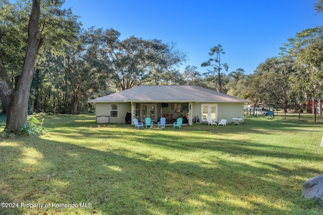 rear view of property with a lawn