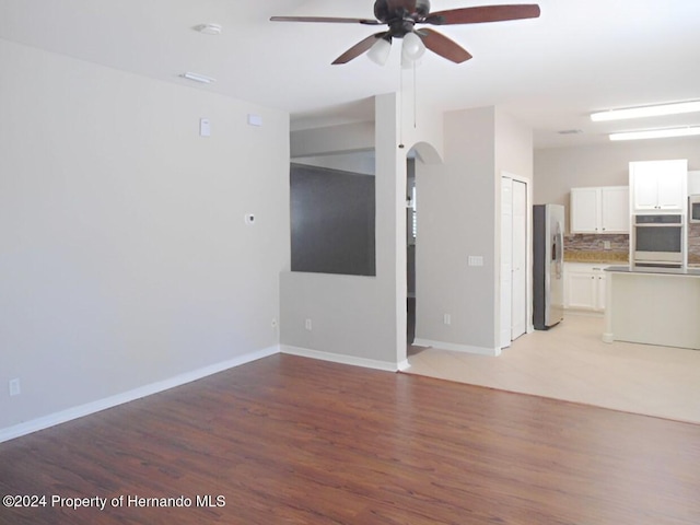 unfurnished living room featuring ceiling fan and light wood-type flooring