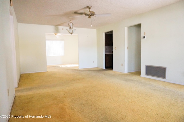 unfurnished room featuring a textured ceiling, light colored carpet, and ceiling fan