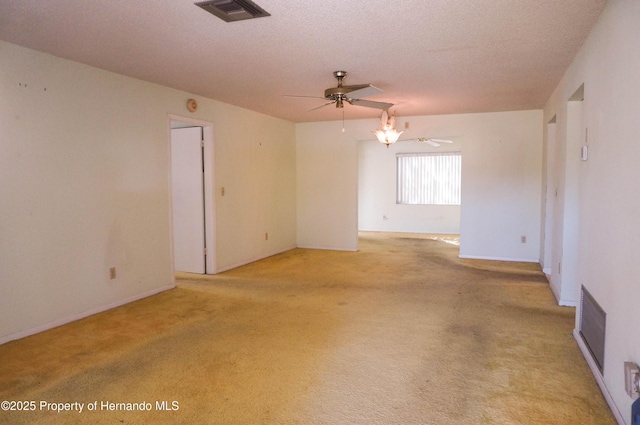 carpeted spare room featuring ceiling fan and a textured ceiling