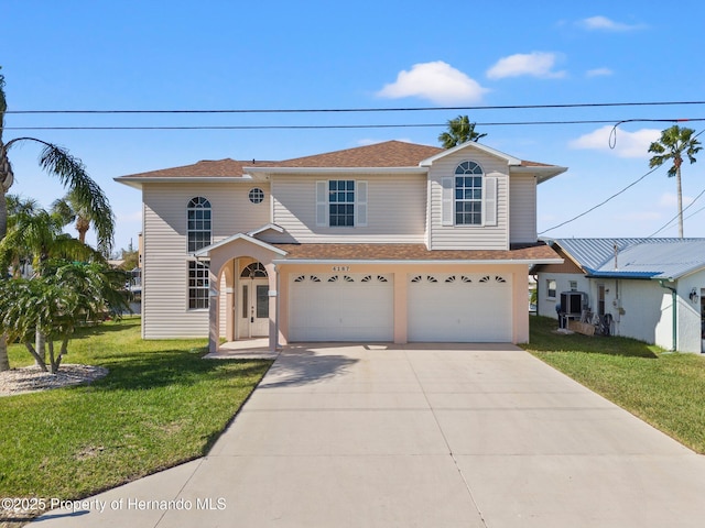 view of front of property with cooling unit, a garage, and a front yard