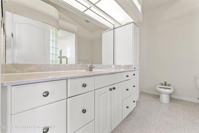 bathroom featuring a bidet, vanity, and vaulted ceiling