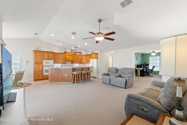 living room featuring lofted ceiling, light carpet, and ceiling fan