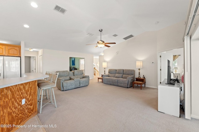 living room featuring ceiling fan, vaulted ceiling, and light carpet