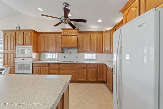 kitchen featuring vaulted ceiling, ceiling fan, backsplash, and white appliances