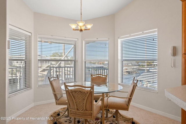 dining area featuring an inviting chandelier, light tile patterned floors, and lofted ceiling