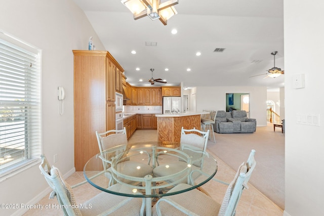 carpeted dining area with ceiling fan