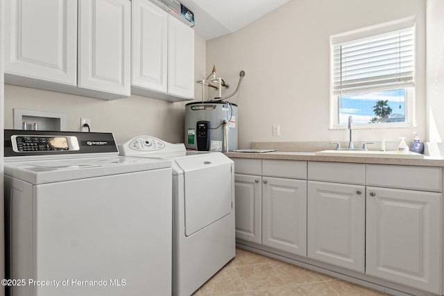 clothes washing area with sink, cabinets, light tile patterned floors, washing machine and dryer, and electric water heater