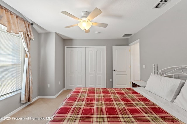 carpeted bedroom featuring ceiling fan and a closet