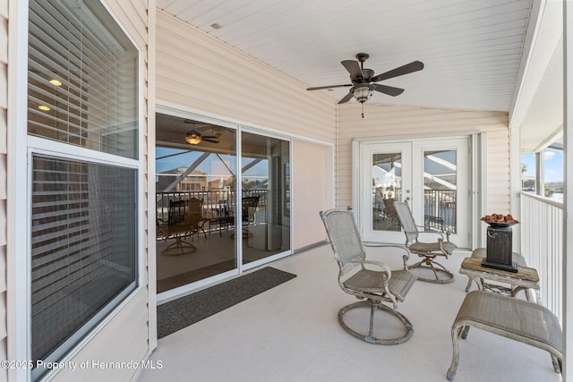 sunroom / solarium with vaulted ceiling, ceiling fan, and french doors