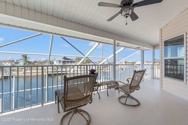 sunroom featuring a water view and ceiling fan