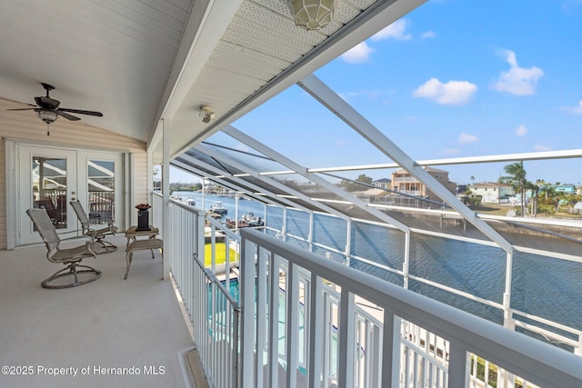 balcony with a water view and french doors