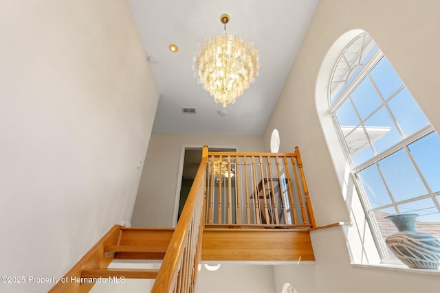 staircase with a chandelier