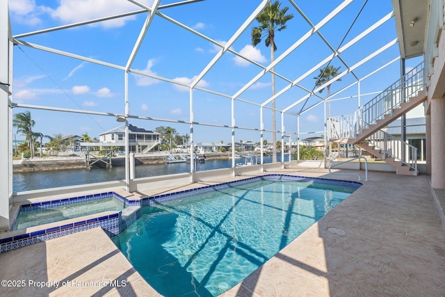 view of swimming pool featuring an in ground hot tub, a water view, glass enclosure, and a patio area