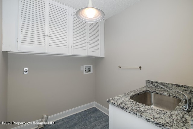 clothes washing area with electric dryer hookup, a textured ceiling, washer hookup, cabinets, and sink