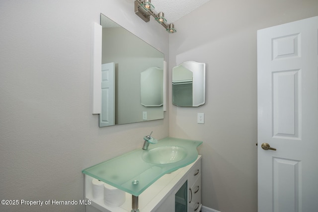 bathroom with a textured ceiling and vanity