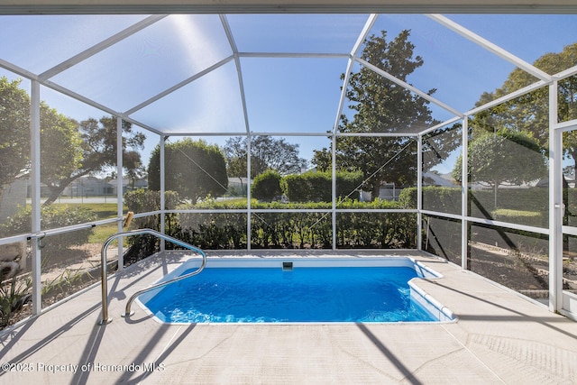 view of swimming pool with a patio area and glass enclosure