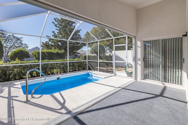 view of swimming pool with a patio area and glass enclosure