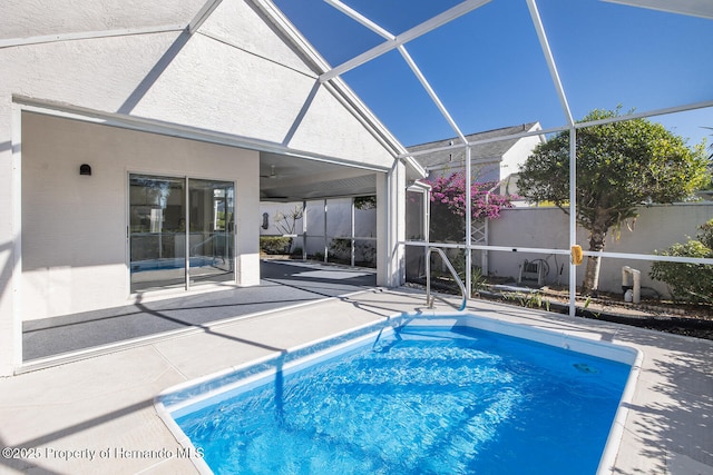 view of pool featuring ceiling fan, glass enclosure, and a patio