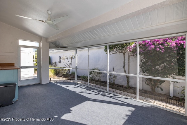 unfurnished sunroom featuring ceiling fan and vaulted ceiling