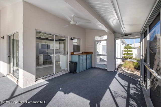 unfurnished sunroom with ceiling fan