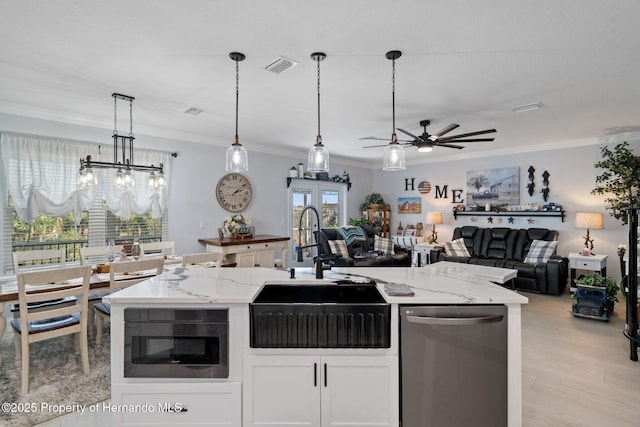 kitchen featuring white cabinets, light stone counters, ceiling fan with notable chandelier, dishwasher, and hanging light fixtures