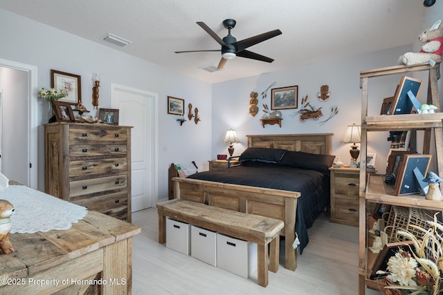 bedroom with ceiling fan and a textured ceiling