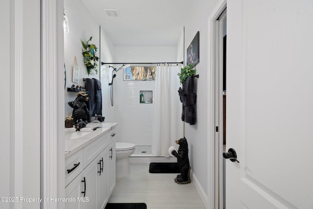 bathroom featuring toilet, vanity, and a shower with shower curtain