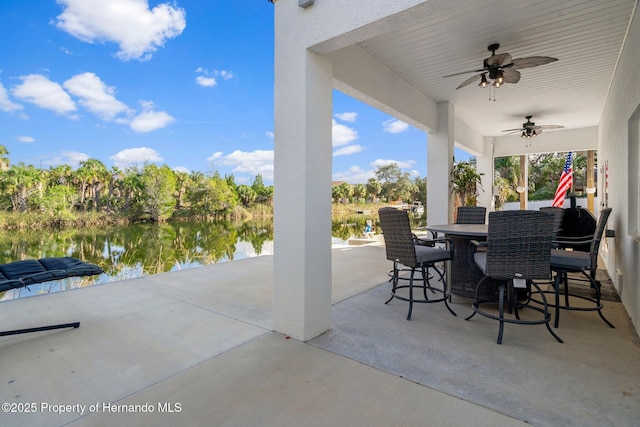 view of patio featuring ceiling fan and a water view