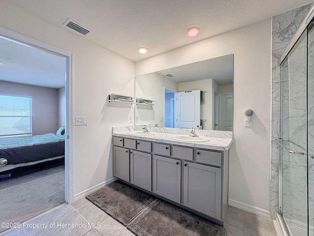 bathroom featuring tile patterned floors, vanity, an enclosed shower, and a textured ceiling