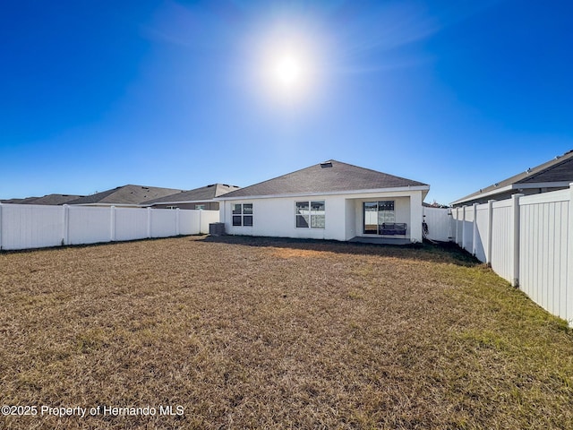 back of house with a lawn and central AC