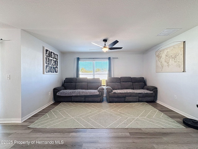 living room with wood-type flooring, a textured ceiling, and ceiling fan